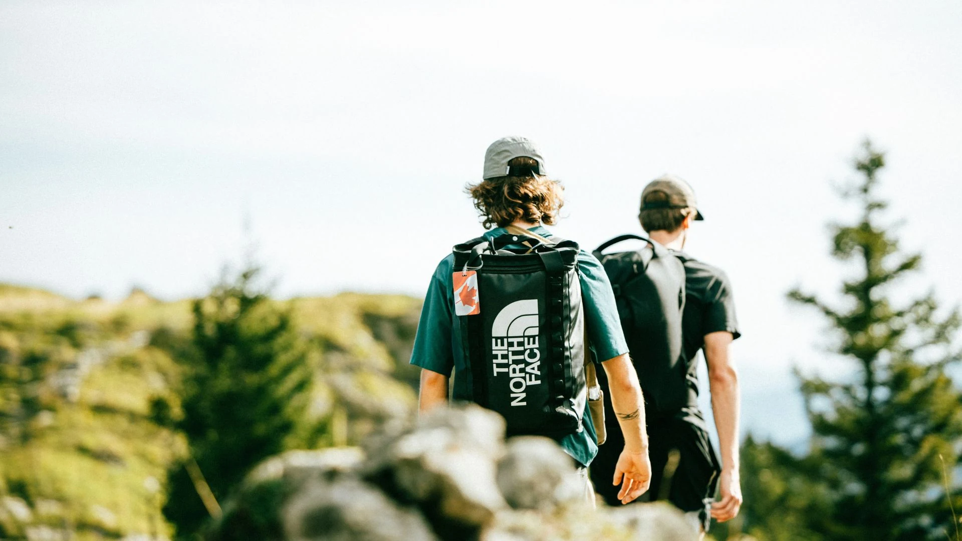 Zwei Sportler mit Rucksäcken auf einem Bergweg